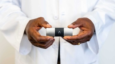 A man holding a KardiaMobil ECG recording device