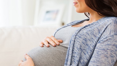 A pregnant woman cradles her stomach