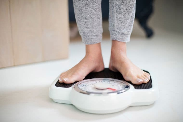 A person, stood on some weighing scales
