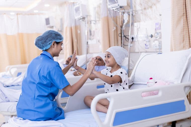 A child, on a cancer ward, playing with a nurse