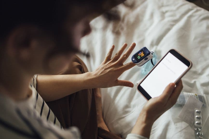 A woman monitors her health at home, using digital medical technology