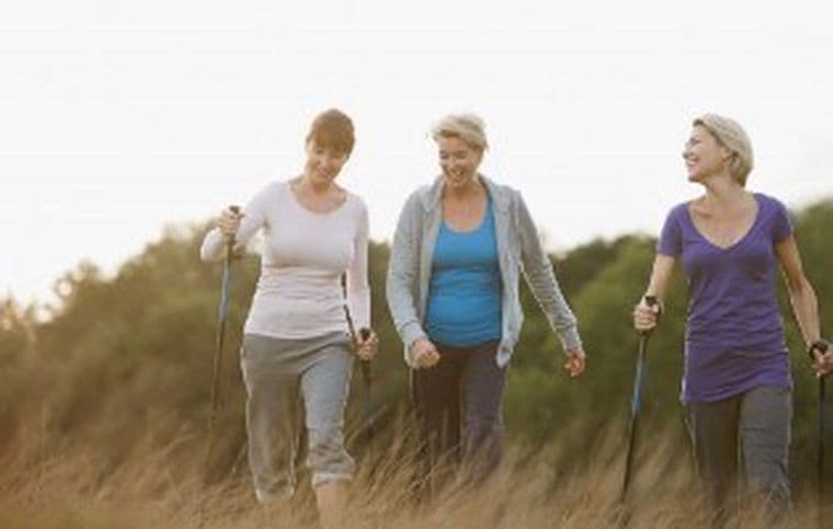 Three women hiking in long grass