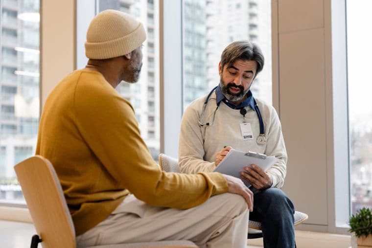 A male cancer patient discussing treatment with a healthcare professional